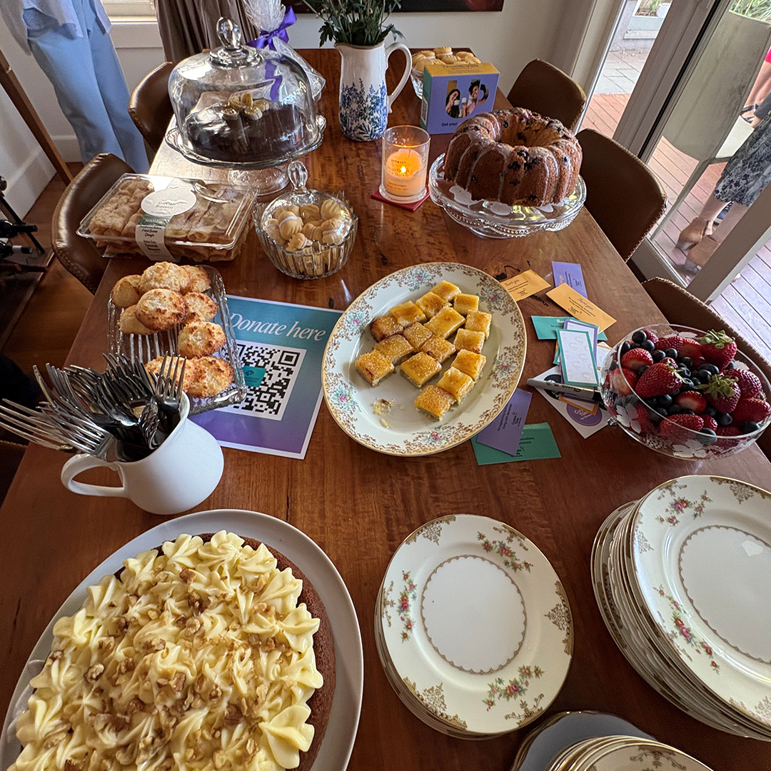 A table full of sweets and a vase of flowers.